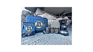 Cuban coffee deployment kit from Search Grounds, displayed in front of disaster rubble with Moka pot, cafecito cups, spoons, and branded gear.