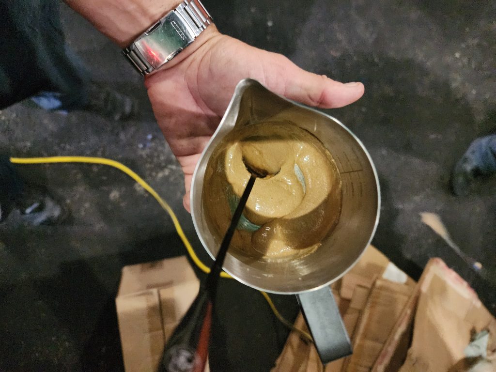 Espumita being whipped in a Search Grounds mixing bowl using the skull-handled spoon during field coffee preparation.