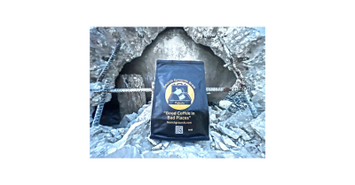 “Search Grounds Brew coffee bag in a rubble pile, showcasing the brand’s theme of providing good coffee in challenging environments.”